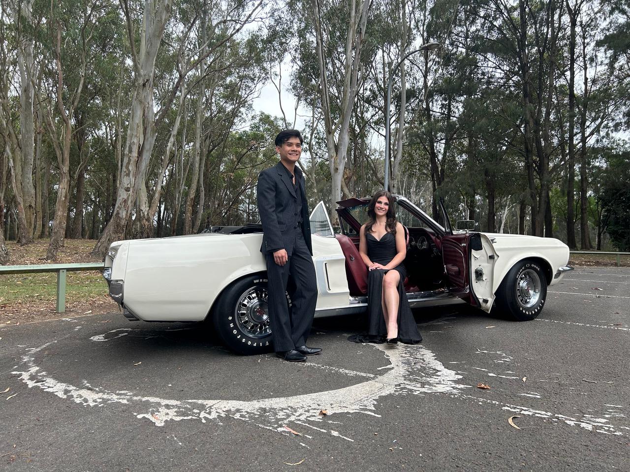 Students posing in formal attire next to a luxury formal car in Sydney before their Year 12 arrival